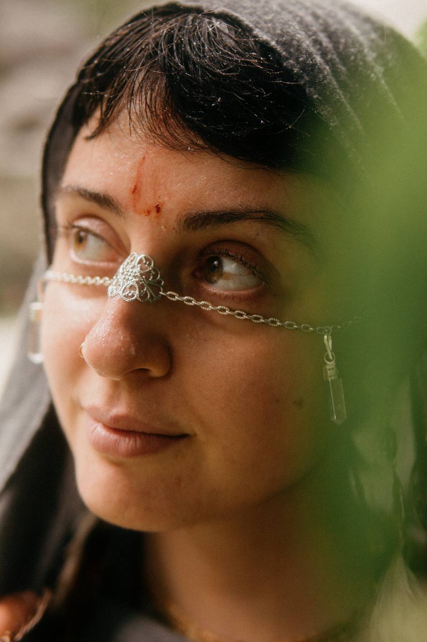 Low-angle portrait of woman wearing gold facechain during golden hour